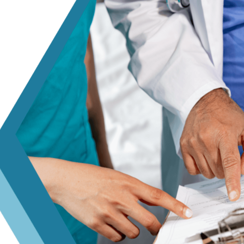Photo of a doctor and nurse pointing at a clipboard with medical documents